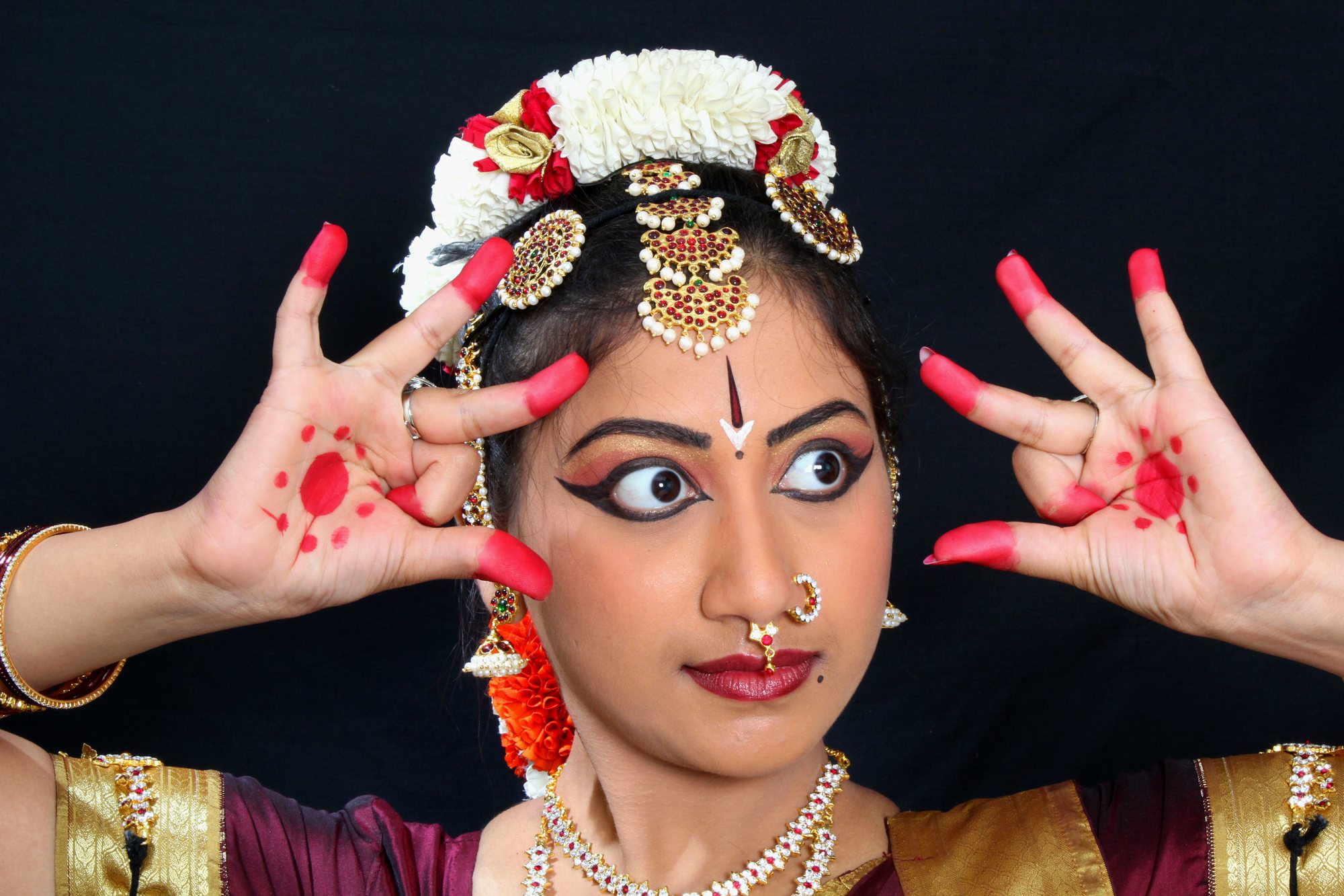Expressive eyes framed by raised hand gestures
